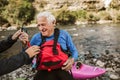 Senior man preparing for kayak tour on a mountain river