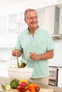 Senior Man Preparing Salad In Modern Kitchen Royalty Free Stock Photo