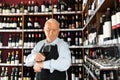 senior man professional sommelier tasting red wines in wine store Royalty Free Stock Photo