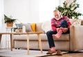 A senior man putting socks on at home at Christmas time. Royalty Free Stock Photo