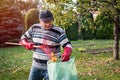 Senior man with rake cleaning garden from fallen leaves Royalty Free Stock Photo