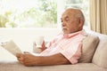 Senior Man Reading Book With Drink At Home Royalty Free Stock Photo