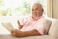 Senior Man Reading Book With Drink At Home Royalty Free Stock Photo