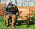 Senior man reading a book having difficulty reading Royalty Free Stock Photo