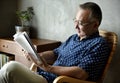 Senior man reading book at home Royalty Free Stock Photo