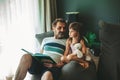 Senior man reading a book to his granddaughter