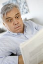 Senior man reading newspaper being surprised Royalty Free Stock Photo