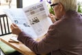 Senior Man Reading Newspaper at Breakfast Royalty Free Stock Photo