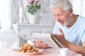 Portrait of senior man reading newspaper duting breakfast Royalty Free Stock Photo