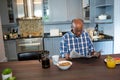 Senior man reading newspaper while having breakfast Royalty Free Stock Photo