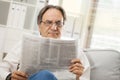 Senior man reading newspaper at home Royalty Free Stock Photo