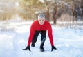 Senior man ready to jog on country road with snow on cold winter day. Active lifestyle and acclimation concept Royalty Free Stock Photo
