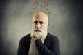 Senior man with red question marks above the head Royalty Free Stock Photo