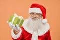 Senior man in red Santa costume holding green gift box Royalty Free Stock Photo