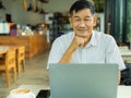 Senior man relaxes and used a laptop and smiles Royalty Free Stock Photo