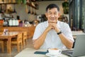 Senior man relaxes and used a laptop in the coffee shop Royalty Free Stock Photo