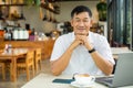 Senior man relaxes and used a laptop in the coffee shop Royalty Free Stock Photo