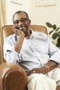 Senior Man Relaxing In Chair At Home Royalty Free Stock Photo