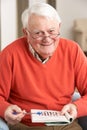 Senior Man Relaxing In Chair At Home Royalty Free Stock Photo