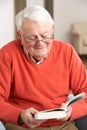 Senior Man Relaxing In Chair At Home Reading Royalty Free Stock Photo