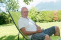 Senior man relaxing in the deckchair in his garden Royalty Free Stock Photo