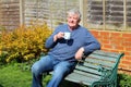 Senior man relaxing drinking coffee in garden. Royalty Free Stock Photo