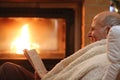 Senior man relaxing by fireplace Royalty Free Stock Photo