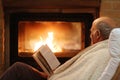 Senior man relaxing by fireplace Royalty Free Stock Photo