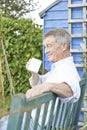 Senior Man Relaxing In Garden With Cup Of Coffee Royalty Free Stock Photo