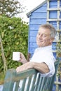 Senior Man Relaxing In Garden With Cup Of Coffee Royalty Free Stock Photo