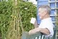 Senior Man Relaxing In Garden With Cup Of Coffee Royalty Free Stock Photo