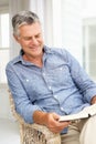 Senior man relaxing at home with a book Royalty Free Stock Photo