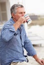 Senior man relaxing outdoors drinking coffee