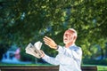 Senior man relaxing in park on a sunny day seated on a wooden bench and waiting for someone Royalty Free Stock Photo