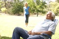 Senior Man Relaxing In Park With Wife