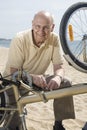 Senior man repairing his bike Royalty Free Stock Photo