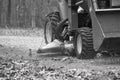 Senior man rides tractor on edge of rocky path