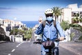 Senior man riding in a deserte road with bicycle and yellow helmet happy for a partial end of the lockdown, facial mask for social Royalty Free Stock Photo