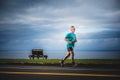 Senior Man Running Alone during the Marathon with Beautiful Ocean Landscape.