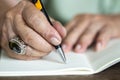 Senior man hand writing letter on ivory colour paper, Notebook,  A black mix silver pen, On wooden background, Art creative idea Royalty Free Stock Photo