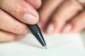 Senior man hand writing letter on ivory colour paper, Notebook, A black pen, Close up & Macro shot, Selective focus, Stationery