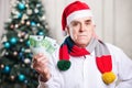 Senior man in Santa's hat holding money Royalty Free Stock Photo