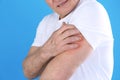 Senior man scratching arm on color background, closeup Royalty Free Stock Photo
