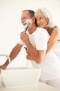 Senior Man Shaving In Bathroom With Wife Watching Royalty Free Stock Photo