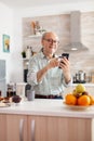 Senior man shopping online using smartphone and holding credit card Royalty Free Stock Photo