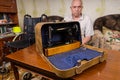 Senior Man Showing his Sewing Machine in a Case