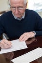 Senior Man Signing Last Will And Testament At Home