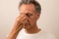 Senior Man with a sinus headache pain rubbing his nose