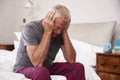 Senior Man Sitting On Bed At Home Suffering From Depression Royalty Free Stock Photo