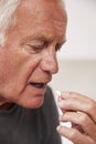 Senior Man Sitting On Bed At Home Taking Medication Royalty Free Stock Photo